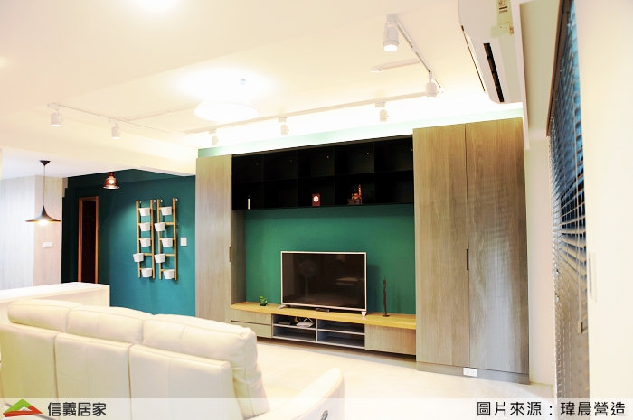 。電視主牆用孔雀綠搭配鐵灰木皮電視櫃，
